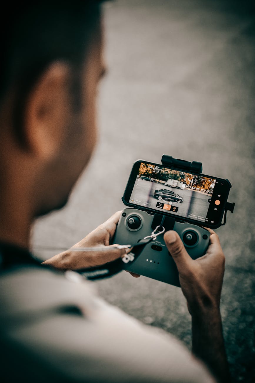 a man using a controller of a drone with a smartphone as a monitor