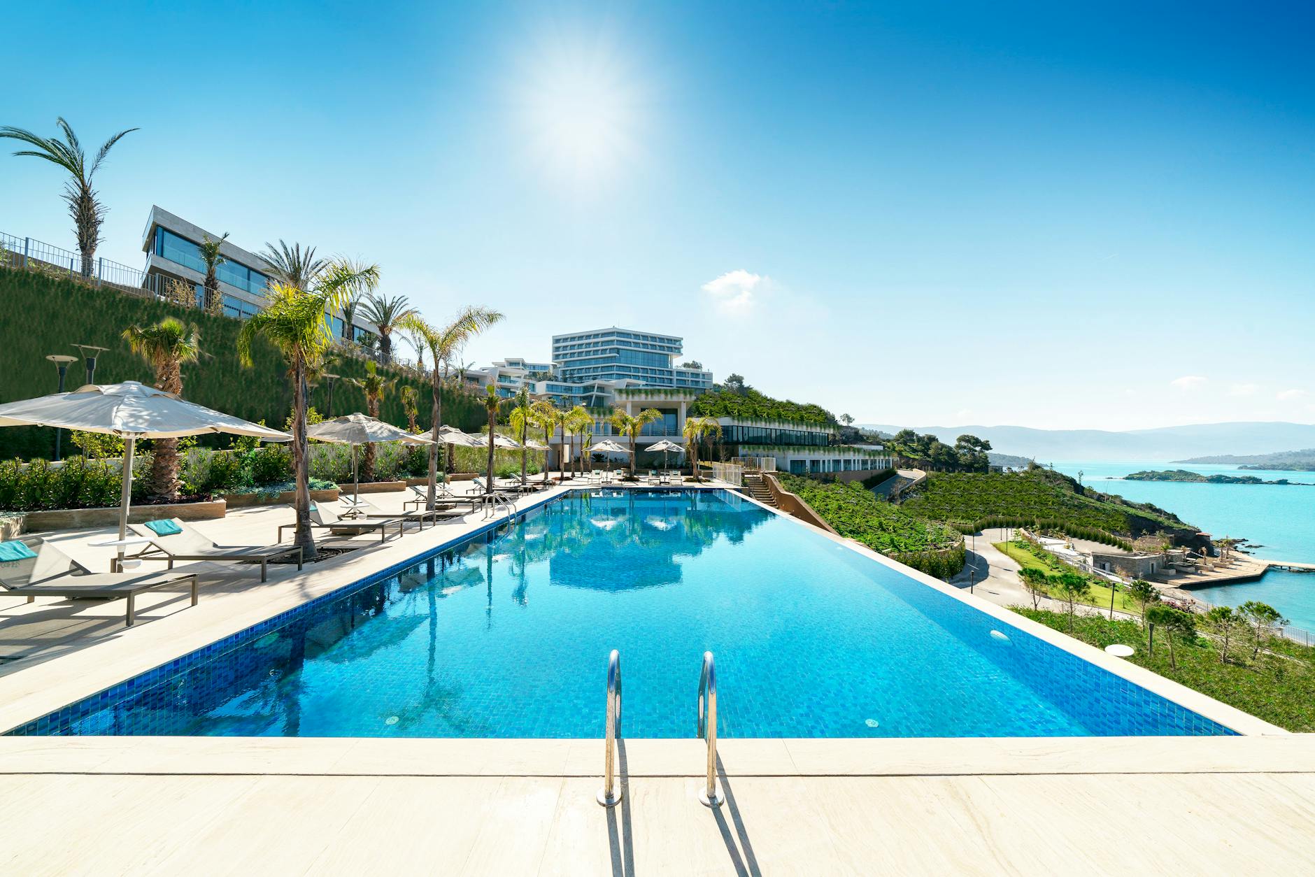 parasol and lounger chair near swimming pool